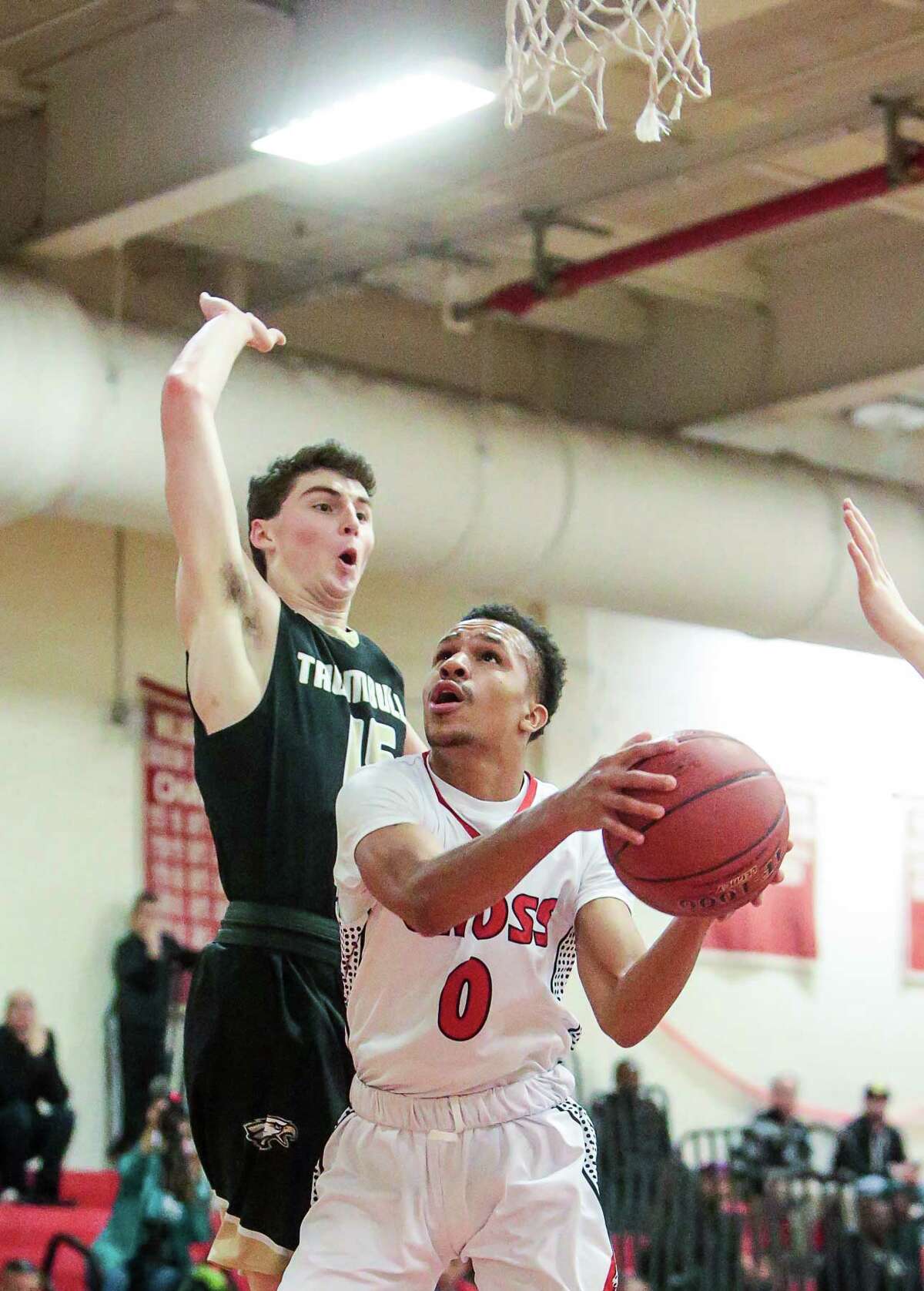 Cross's Kwane Taylor goes up for layup on Trumbull defender Chris Brown during the Governor's 67-65 win Friday night in New Haven.