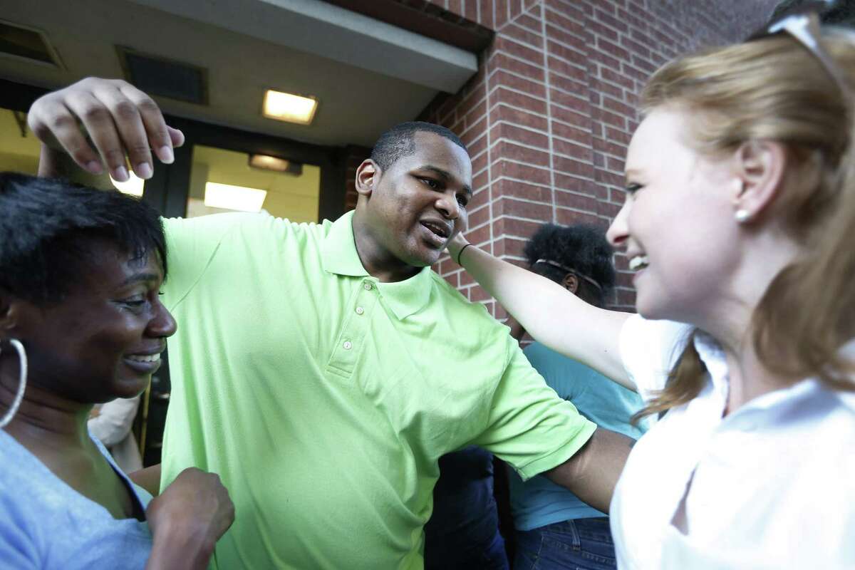 Alfred Brown reaches out to hug Houston Chronicle columnist Lisa Falkenberg after his release from the Harris County jail on Monday, June 8, 2015, in Houston.