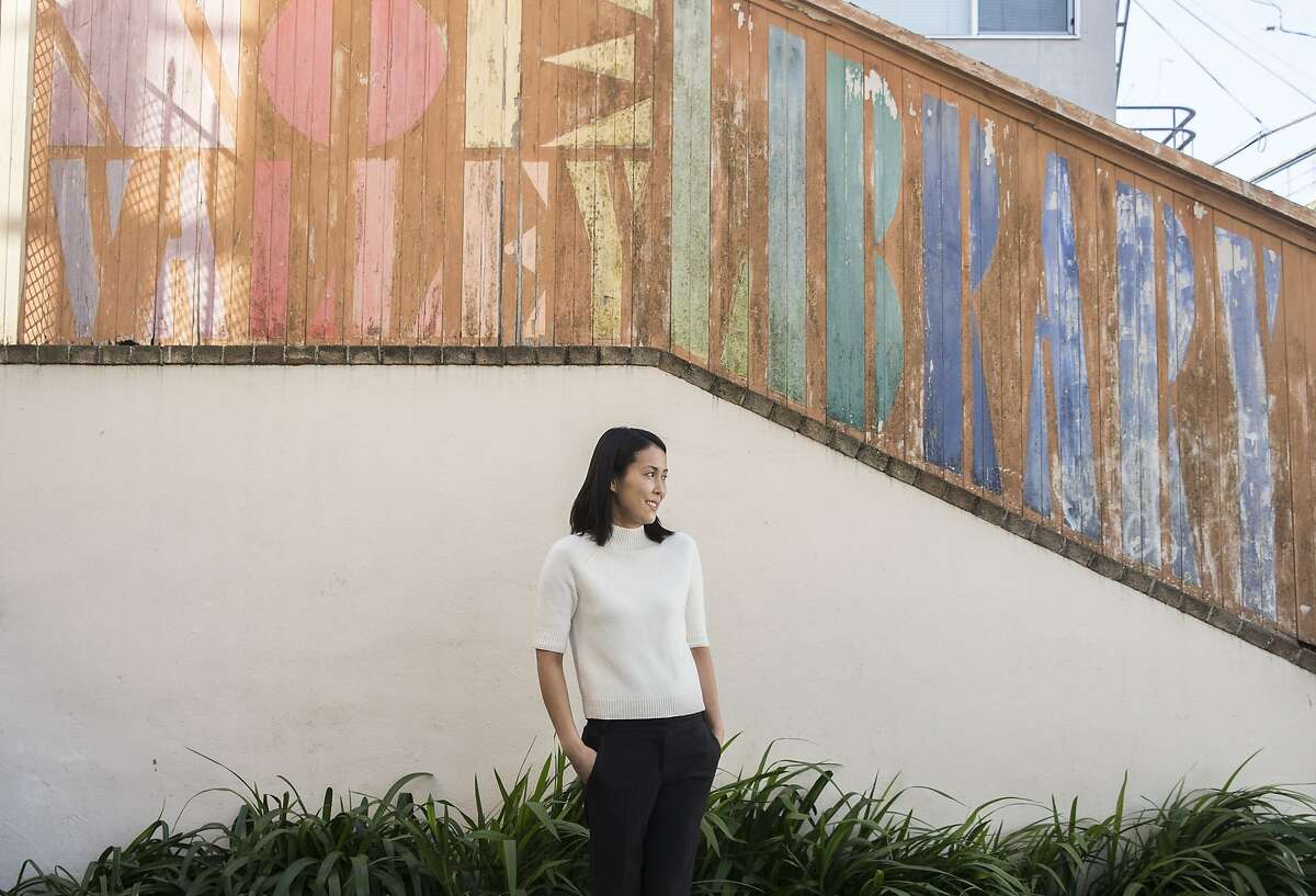 San Francisco filmmaker Atsuko Hirayanagi poses for a portrait in front of a painted sign outside San Francisco Public Library's Noe Valley branch, the same location where she wrote the script for her new movie ?Oh Lucy!?, Friday, Feb. 16, 2018 in San Francisco, Calif.