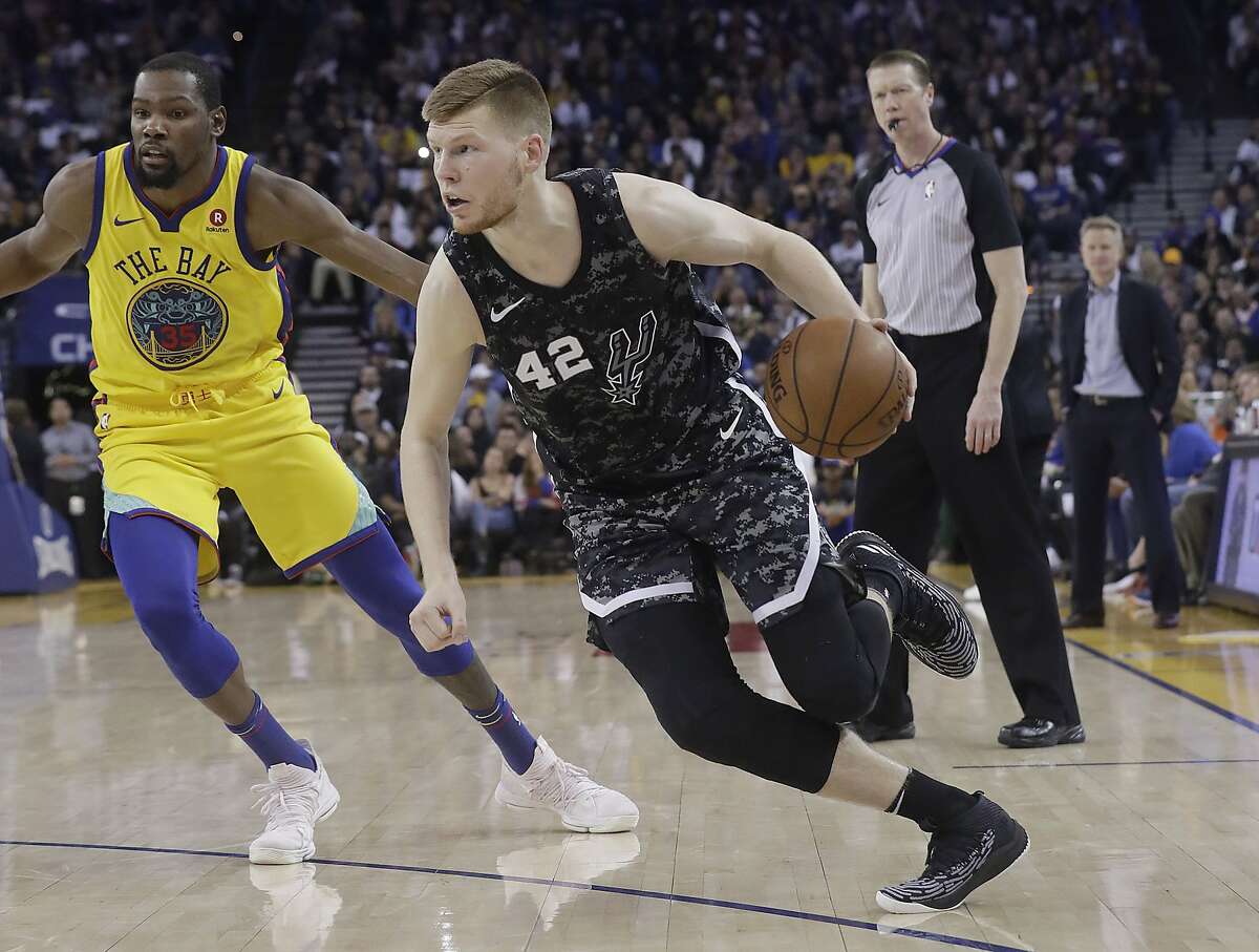 San Antonio Spurs forward Davis Bertans (42) dribbles in front of Golden State Warriors forward Kevin Durant (35) during the second half of an NBA basketball game in Oakland, Calif., Thursday, March 8, 2018. (AP Photo/Jeff Chiu)