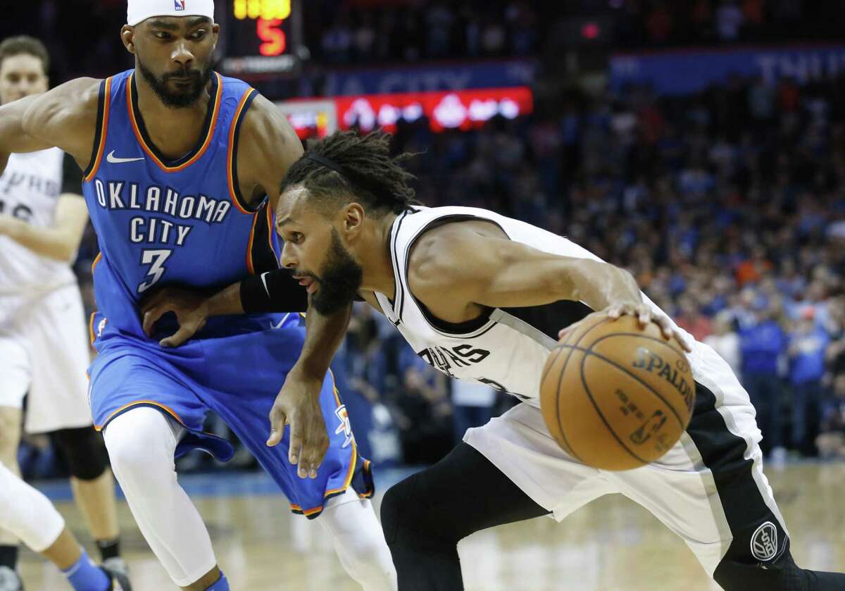 San Antonio Spurs guard Patty Mills, right, drives around forward Oklahoma City Thunder Corey Brewer (3) in the first half of an NBA basketball game in Oklahoma City, Saturday, March 10, 2018. (AP Photo/Sue Ogrocki)