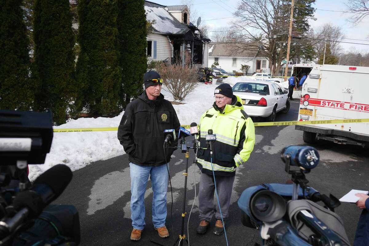 Rensselaer Police Detective, Scott Earing, left, and Rensselaer Assistant Fire Chief, Jay Cocoran talk to members of the media near the home at 900 Mann Ave., as the investigation continues into an early morning fire on Sunday, March 11, 2018, in Rensselaer, N.Y. (Paul Buckowski/Times Union)