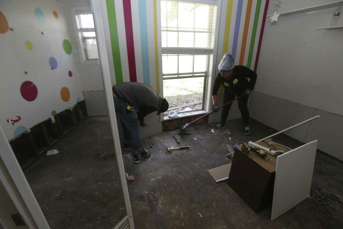 Jonny Guilarte Rodriguez replaces sheetrock while Nilsa Almira cleans up the derbirs at Tracy Wilson's flooded house on Thursday, March 1, 2018, in Houston. Wilson signed up for Texas Rebuild's PREPS program, which is a FEMA housing program that provides up to $20,000 in repair work for flooded homes, to fix her house. ( Yi-Chin Lee / Houston Chronicle )