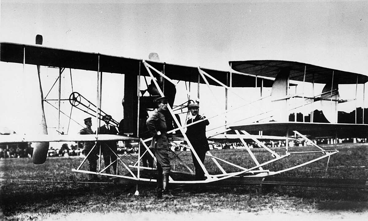 The U.S. president and 7,000 spectators gathered to watch the Wright brothers demonstrate their military flyer for the second time to the U.S. Army at Fort Myer, Va., July 30, 1909. Orville Wright took First Lt. Benjamin D. Foulois as observer on a 10-mile cross country flight to Shuter's Hill, Alexandria, Va., and back, completing all the terms of the sale for the world's first military plane. Standing near the propellers are Lt. Foulois (left) and Wilbur Wright. At the tail end are Lt. Frank P. Lahm (left) and Orville Wright.