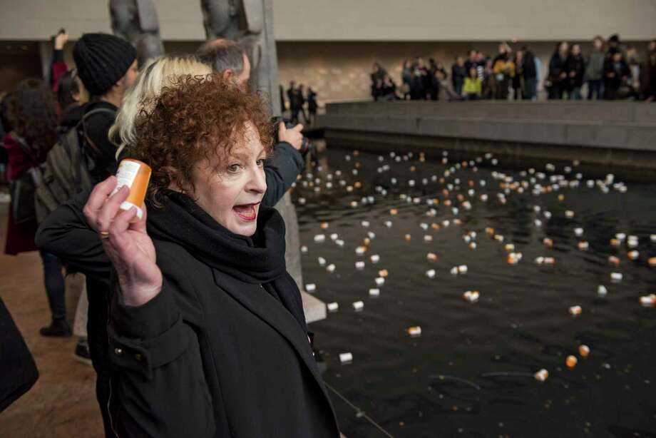 Photographer Nan Goldin leads a group protesting, in part by throwing prescription bottles into a reflecting pool in the Sackler Wing of the Metropolitan Museum of Art -- named for a family connected to the sales and marketing of OxyContin -- in New York, March 10, 2018. the protesters called for cultural institutions to reject money from the Sackler family and demanded, among other things, that Purdue Pharma, which has been accused of using deceptive and aggressive tactics to market OxyContin, fund addiction treatment. (George Etheredge/The New York Times) Photo: GEORGE ETHEREDGE / NYTNS