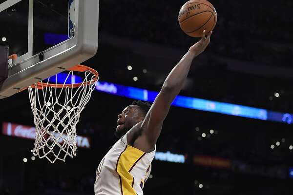 Los Angeles Lakers forward Julius Randle, left, goes up for a dunk against Cleveland Cavaliers forward Jeff Green, center, and forward Larry Nance Jr. during the second half of an NBA basketball game, Sunday, March 11, 2018, in Los Angeles. The Lakers won 127-113. (AP Photo/Mark J. Terrill)