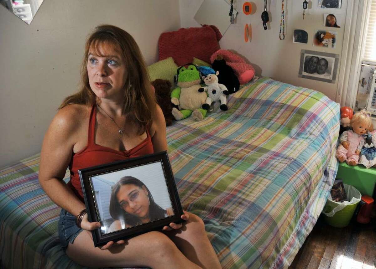 Lisa Seymour holds a photo of daughter Cherelle Clarke, a Schenectady High School student who killed herself. She appears in the girl's bedroom and continues to mourn her loss. (John Carl D'Annabelle)