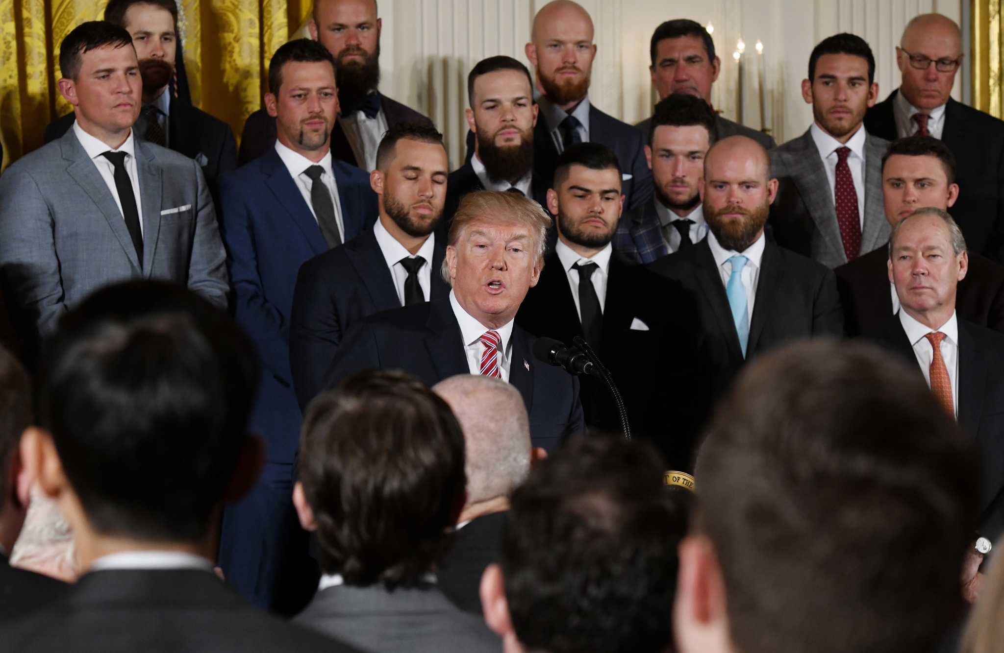 President Donald Trump (L) receives a custom jersey from Houston Astros  outfielder Josh Reddick as Trump welcomes the 2017 World Series Champion  Houston Astros to the White House on March 12, 2018