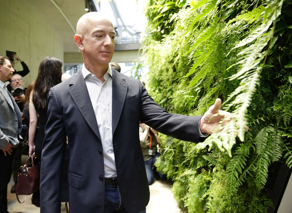Chief Executive Officer of Amazon, Jeff Bezos, tours the facility at the grand opening of the Amazon Spheres, in Seattle, Washington on January 29, 2018. Amazon opened its new Seattle office space which looks more like a rainforest. The company created the Spheres Complex to help spark employee creativity. / AFP PHOTO / JASON REDMOND (Photo credit should read JASON REDMOND/AFP/Getty Images)
