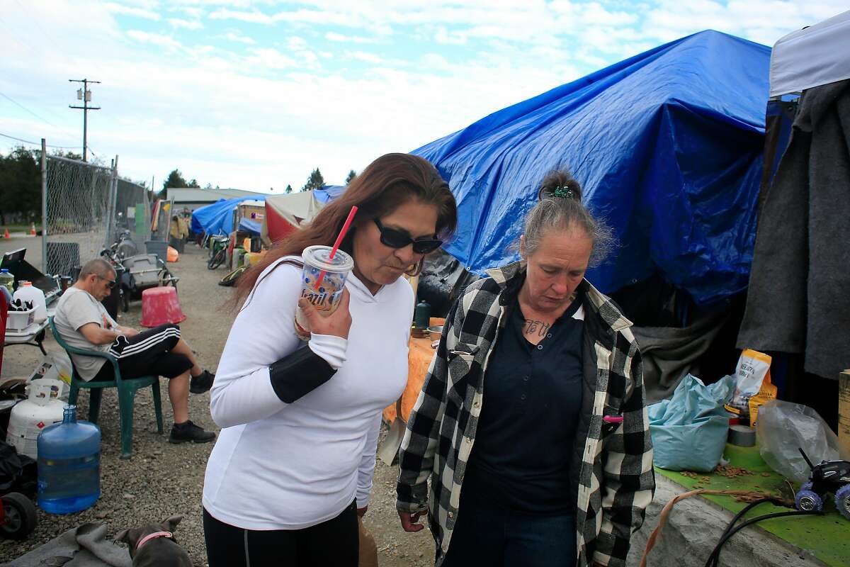 Betty Band (l to r) and Ellen Brown talk outside a tent at Last Chance Village on Wednesday, March 7, 2018, in Santa Rosa, Calif.
