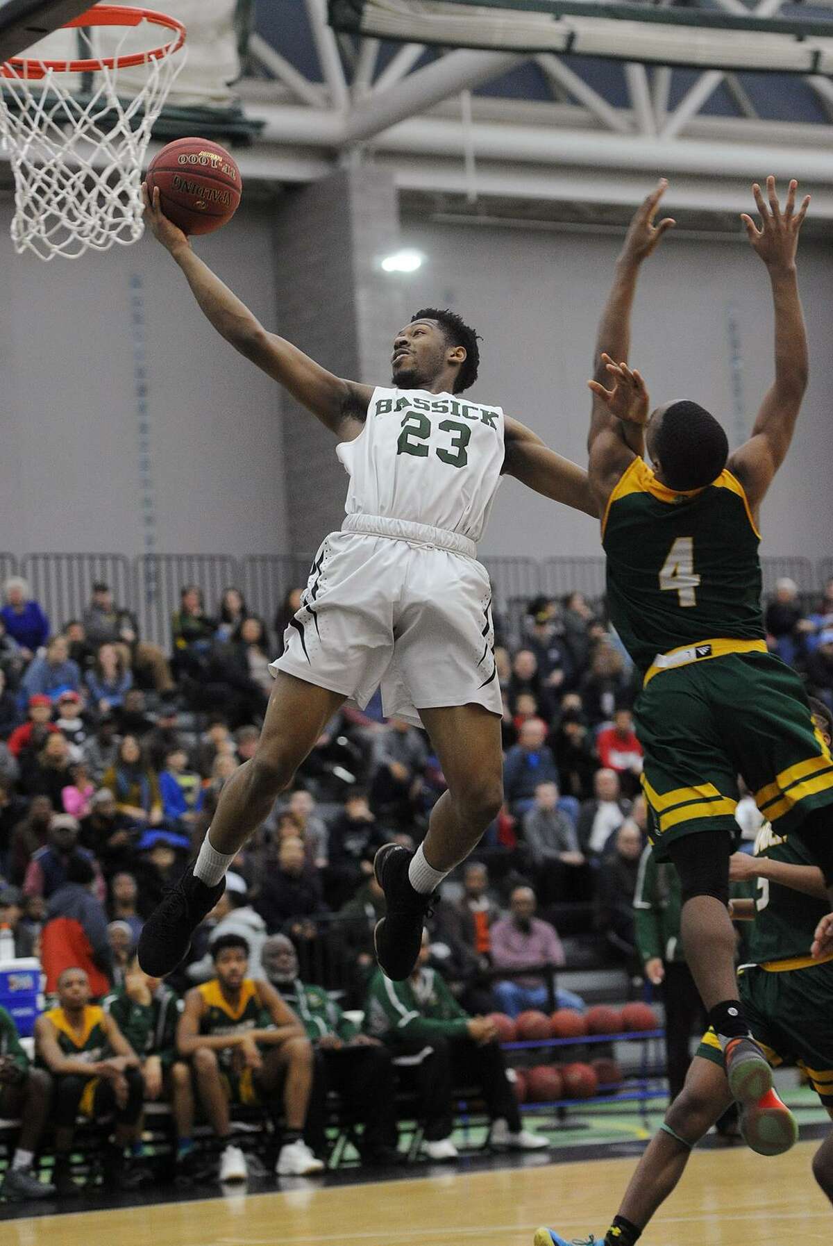 Bassick’s Jordan Gallimore drives to the basket ahead of Hamden’s Douglas Daniels during their Division 1 quarterfinal game on Monday night at the Floyd Little Athletic Center in New Haven.