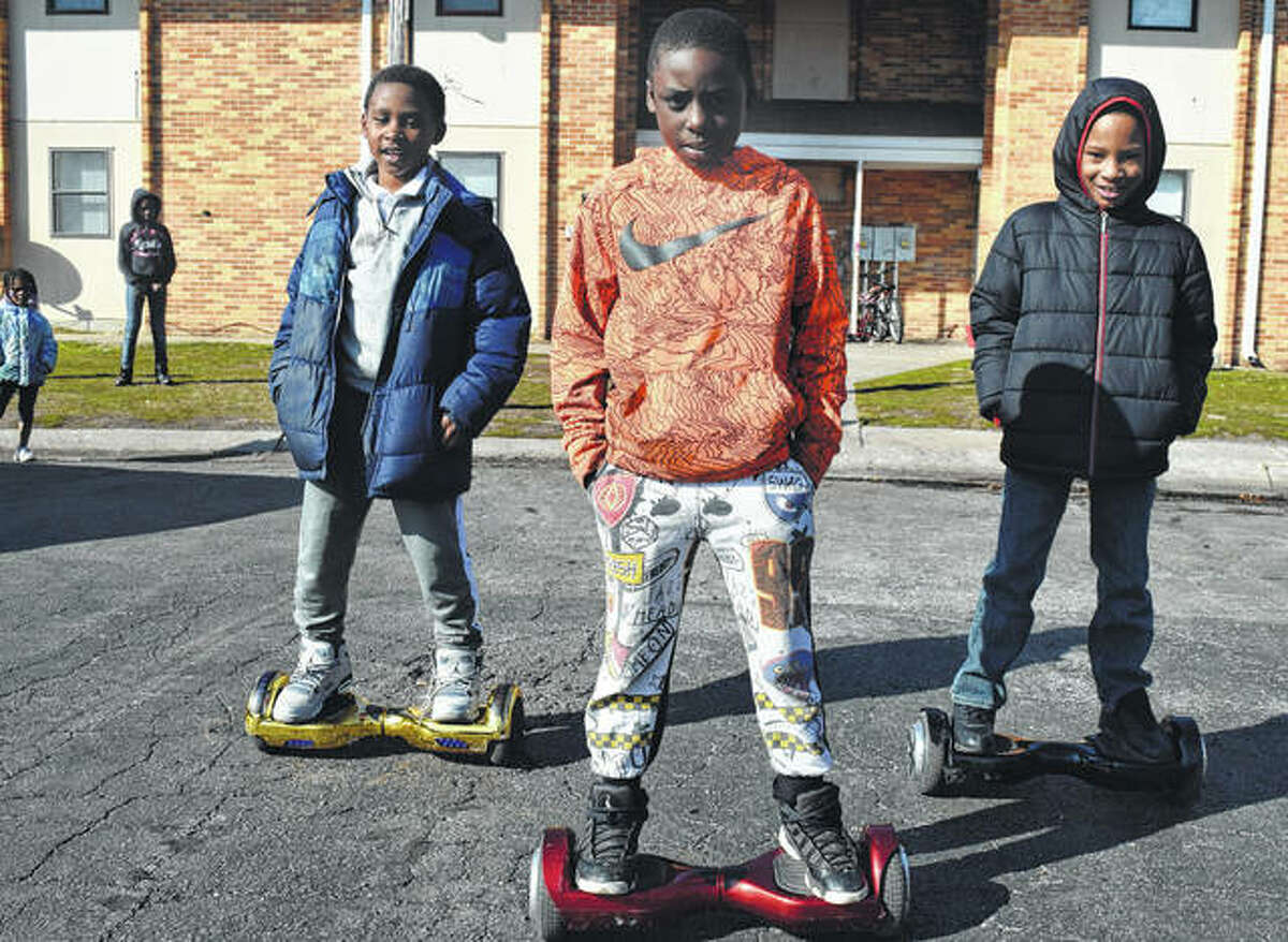 Lincoln Elementary School students Christopher Hill (from left), 9, Kavion Baker, 8, and Ka’rell Rattler, 8, ride their hoverboards after school Monday on Walnut Street.