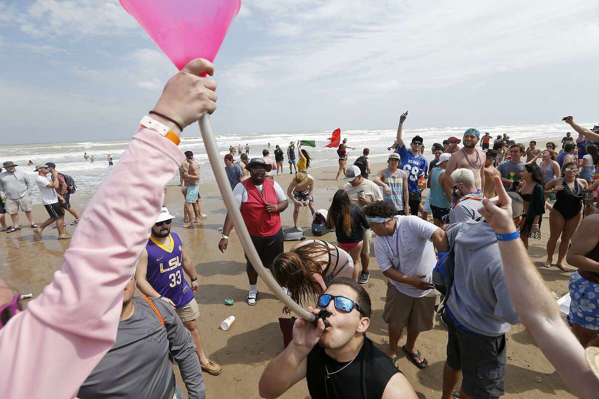 Texas A&M student John Gilcrease drinks from a beer bong while enjoying spring break Monday March 12, 2018 on South Padre Island, Tx.