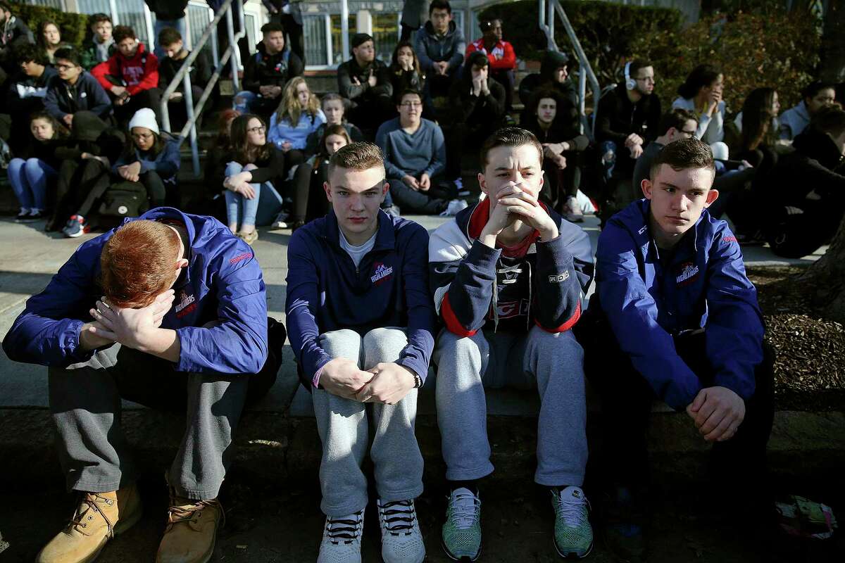 FILE - In this Feb. 28, 2018, file photo, Somerville High School students sit on the sidewalk on Highland Avenue during a student walkout at the school in Somerville, Mass. A large-scale, coordinated demonstration is planned for Wednesday, March 14, when organizers have called for a 17-minute school walkout nationwide to protest gun violence. (Craig F. Walker/The Boston Globe via AP, File)