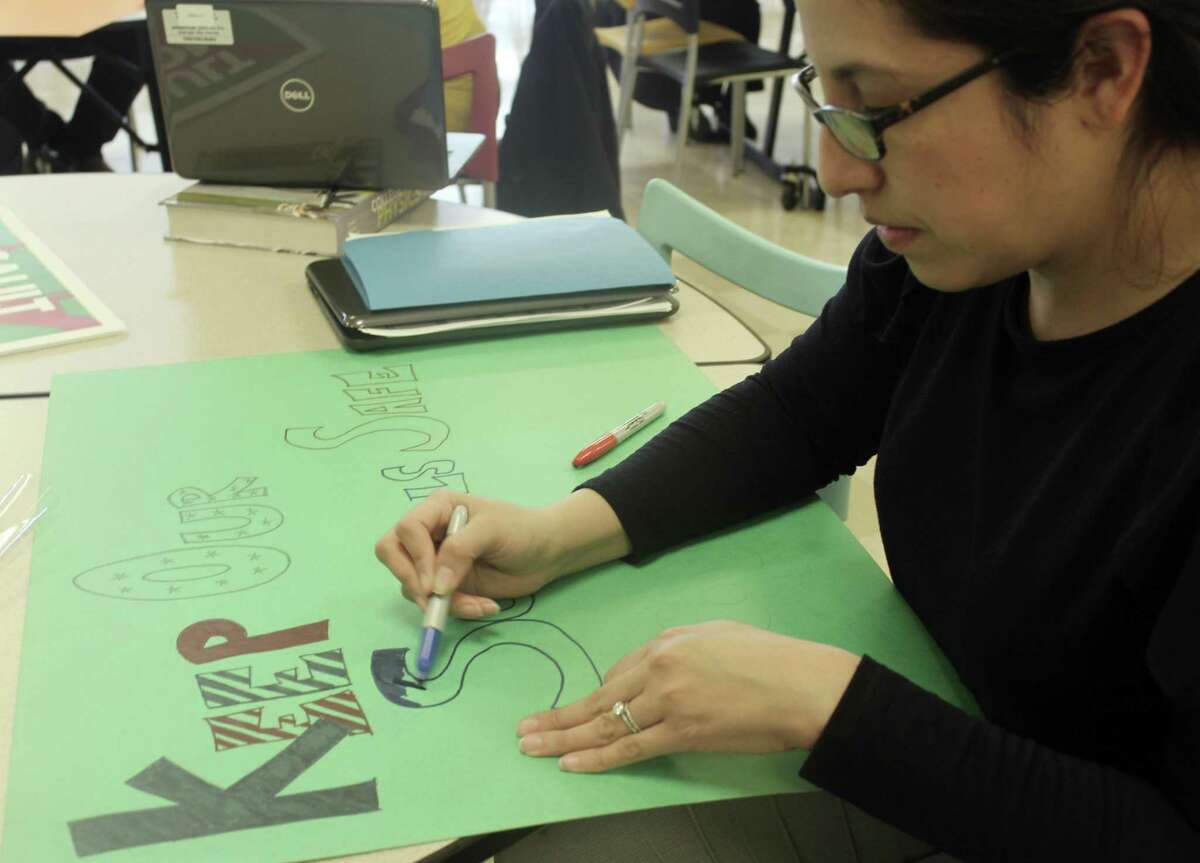 Maria DeAntonis, a guidance counselor at the Academy of Information Technology and Engineering in Stamford, Conn., works on a sign after school on March 12, 2018 for a teacher "walk-in" planned in conjunction with the student walkout on March 14. The goal of the walk-in is to push Congress to take action to make schools safer.