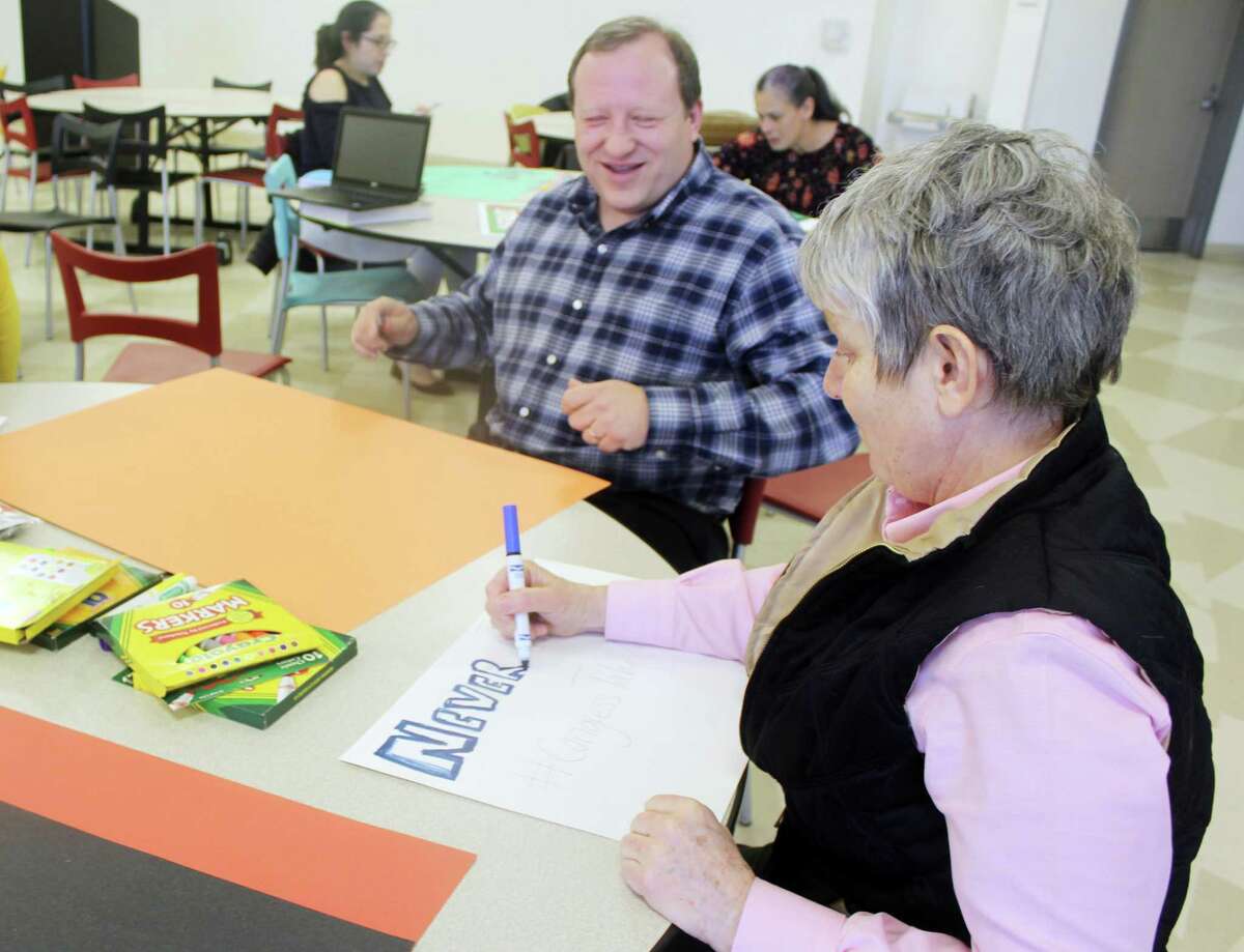 Claude Morest, a social studies teacher at the Academy of Information Technology and Engineering in Stamford, Conn., with guidance counselor Christine Bisceglie, work on signs afterschool on March 12, 2018 for a teacher "walk-in" planned in conjunction with the student walkout on March 14. The goal of the walk-in is to push Congress to take action to make schools safer.
