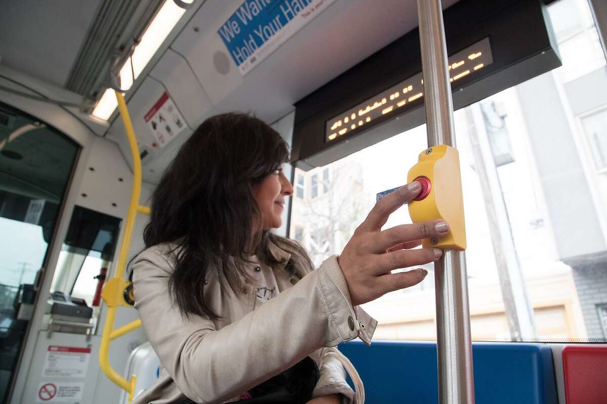 Gina Gonzales presses a stop button on a new Muni Metro light rail car on Monday, March 12, 2018 in San Francisco, CA