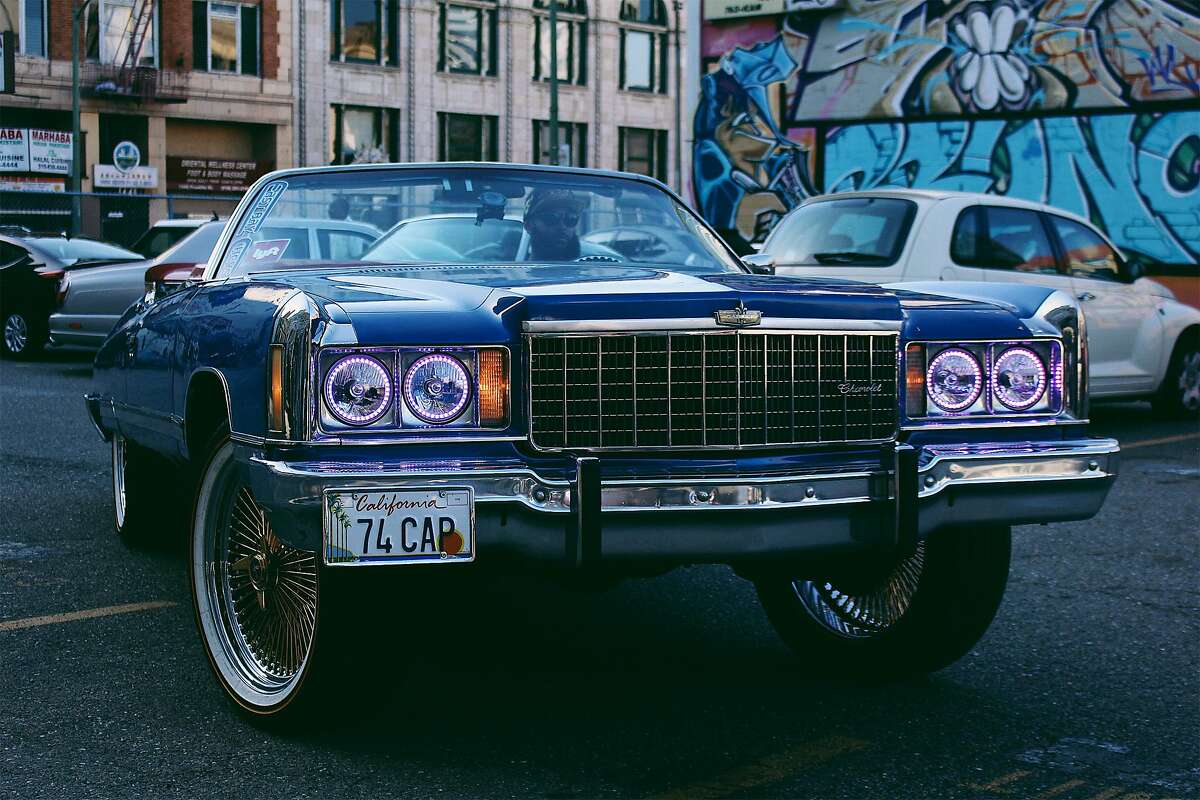 The museum exhibition, described as a living history show on hip-hop, has cultural references as well as musical ones, including Amanda Sade’s image of DropReg, president of the East Bay Chevs group, in his ride at an Oakland video shoot.