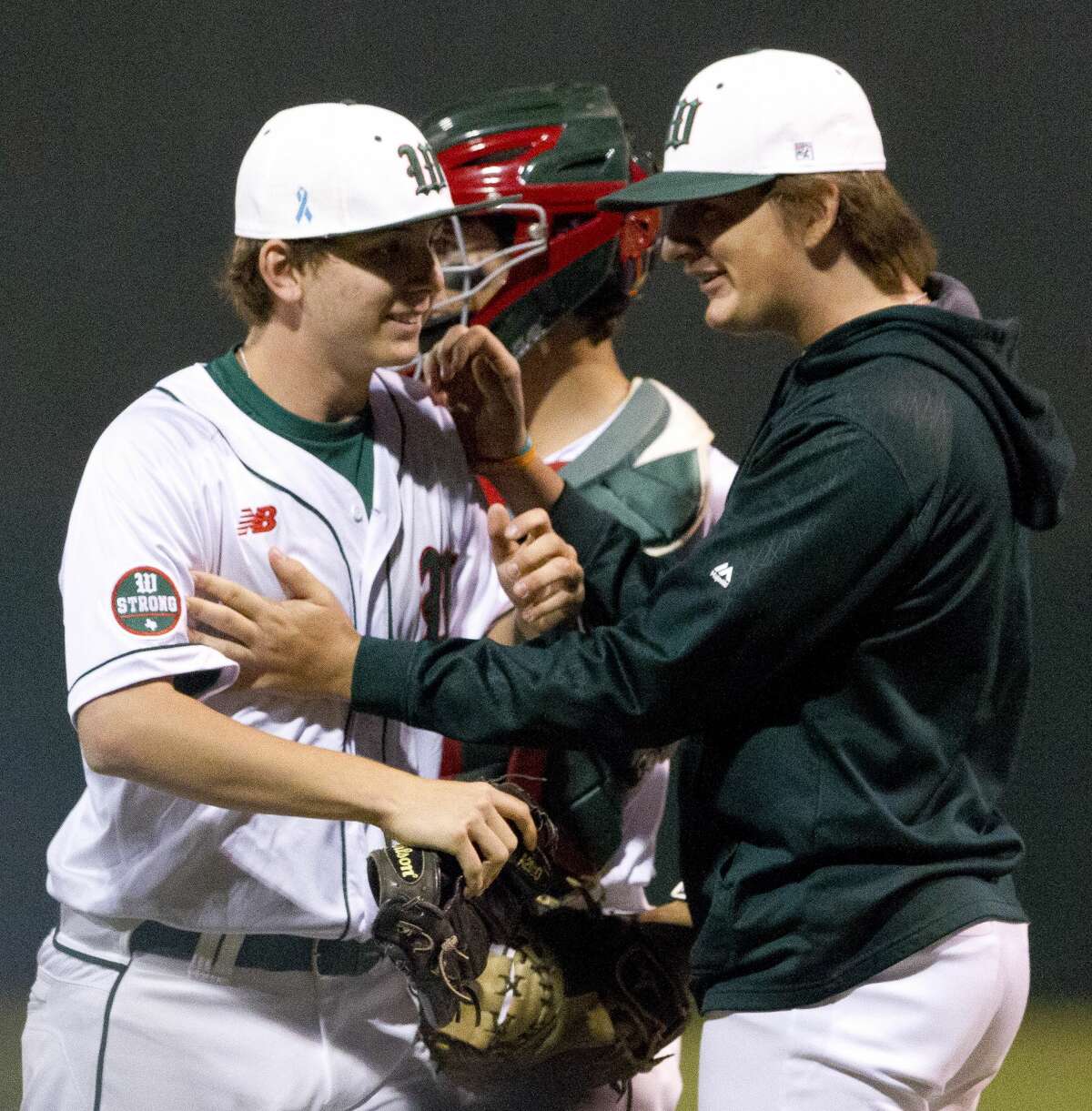 The Woodlands starting pitcher Steven Beard (16) is greated by teammates after the final out of the seventh inning as the Highlanders defeated Montgomery 3-1 in the first District 12-6A game of the season, Tuesday, March 13, 2018, in The Woodlands.