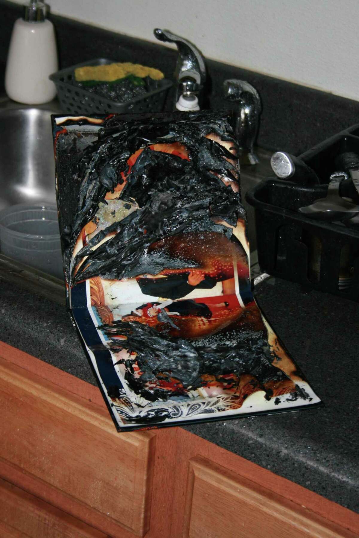The burned wedding album lying next to a sink in a Perry Street apartment that set off the sprinkler system  in the apartment of a recently divorced woman as well as three neighboring units.