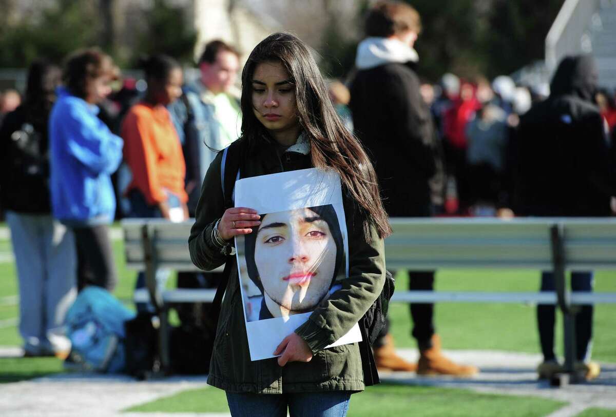 Norwalk High School students including junior Adriana Gudiel as well as school staff and guests gather on the football field for a reading of names and a moment of silence for those who died in the Parkland, Florida school shooting Wednesday, March 14, 2018, at the high school in Norwalk, Conn.