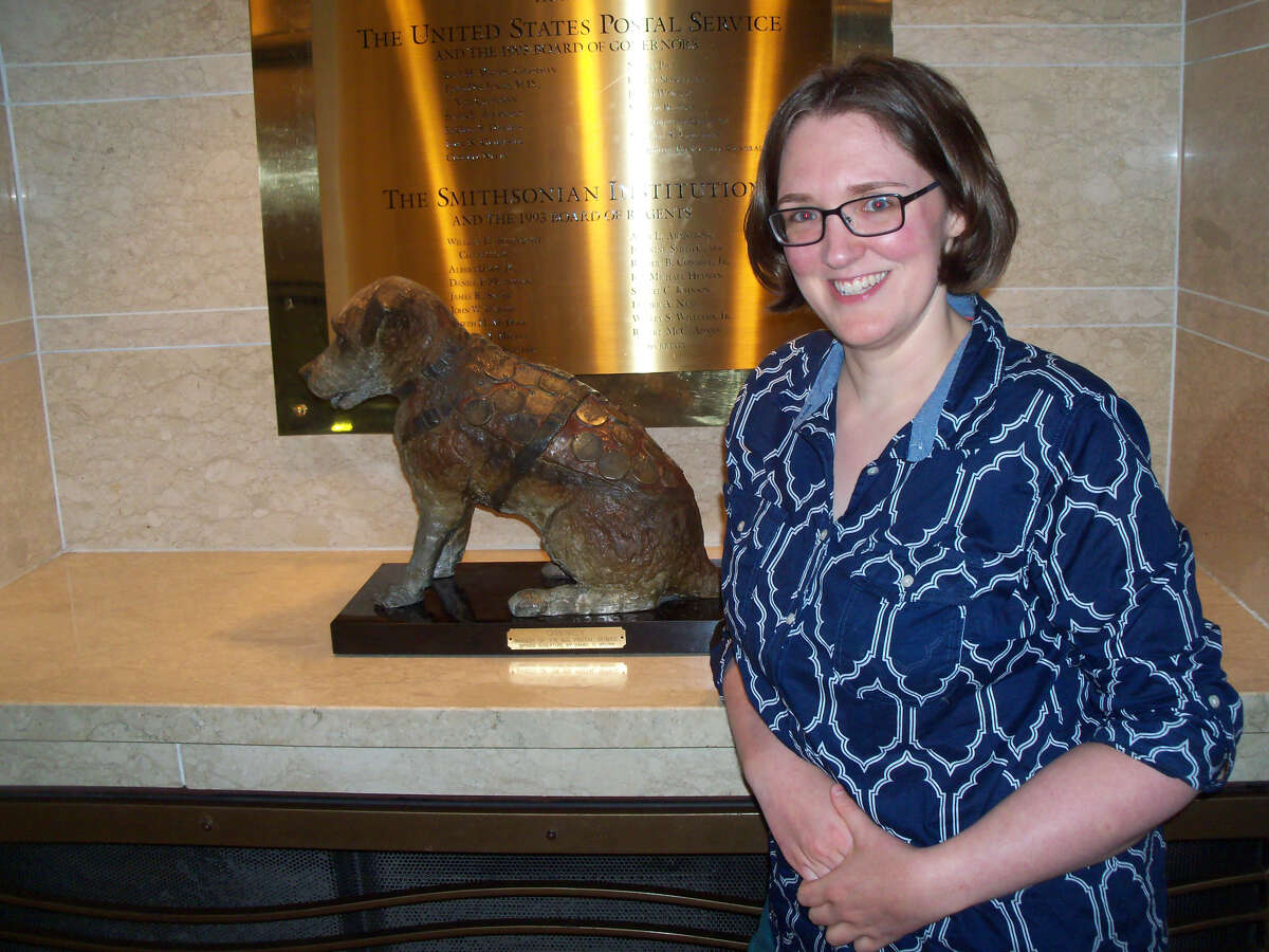 Historian and author Kelli Huggins with a statue of the Albany-based railroad dog Owney at the National Postal Museum. The museum also has Owney's preserved body on view. (Photo courtesy Kelli Huggins.)