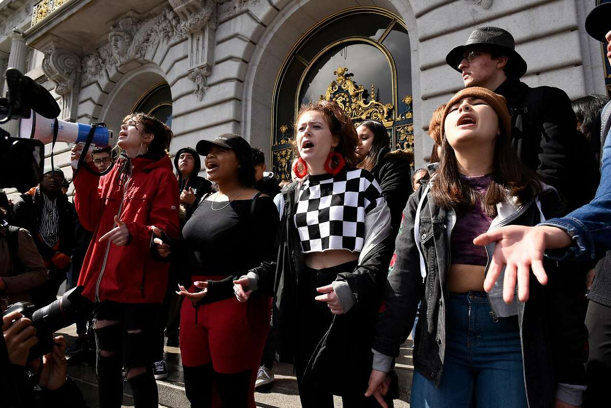 Members of the Ruth Asawa School of the Arts spoken arts department Morgen York, left, Jyairrh Martin, Talia Kishinevsky, and Samantha Friedman read a piece to the crowd gathered in front of City Hall in San Francisco, Calif., on Wednesday March 14, 2018. Students across the country participate in a national walkout to oppose gun violence.
