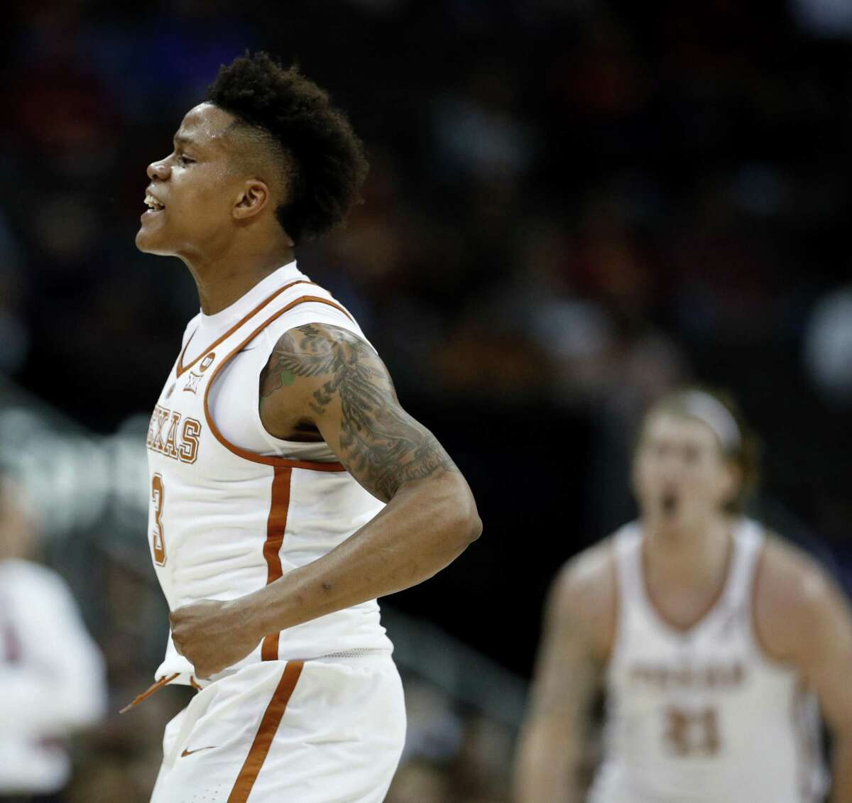 Texas' Jacob Young celebrates a teammate's basket during the first half of an NCAA college basketball game against Iowa State in the Big 12 men's tournament Wednesday, March 7, 2018, in Kansas City, Mo. (AP Photo/Charlie Riedel)