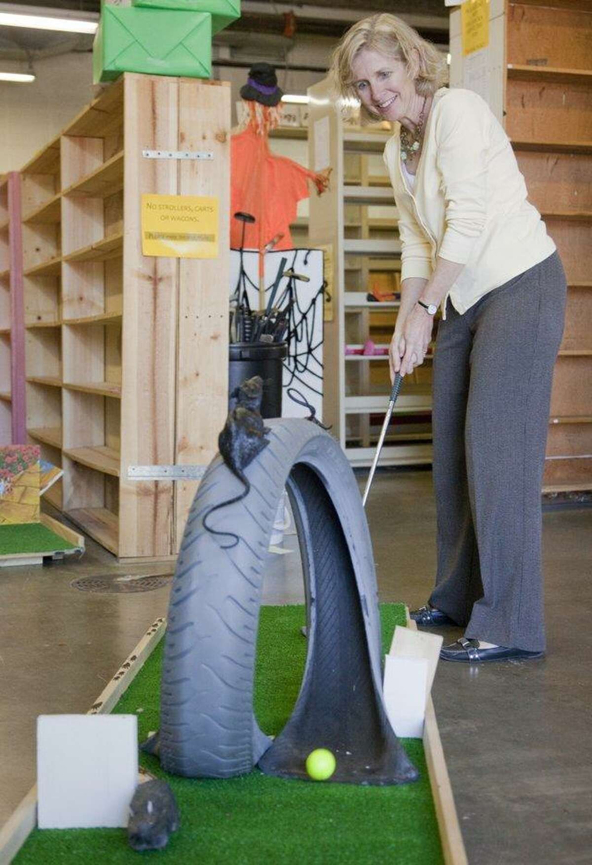 Indoor library mini-golf is not as crazy as it sounds. Shown is Kathleen Morgan, development director for the Lawrence (Kansas) Public Library, as she plays a hole. The Fairfield Public Library has its own similar family event on March 25.