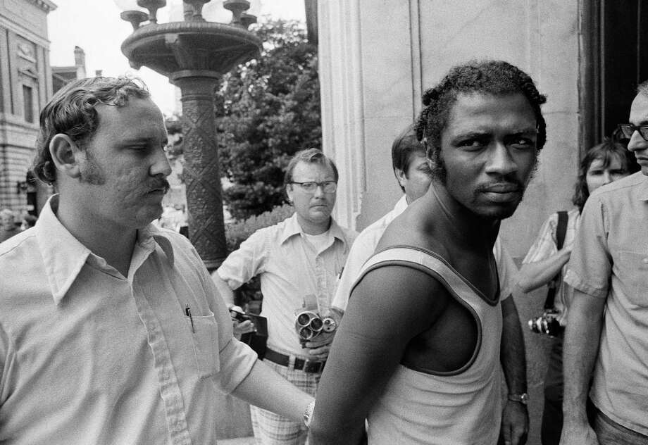 FILE- In this Sept. 1, 1973 file photo, Herman Bell, right, glares at the media following his arrest in New Orleans. The former member of the Black Liberation Army, who was convicted of fatally shooting two New York City police officers in 1971, has been granted parole and will be realized from Shawangunk Prison on April 17, 2018. (AP Photo) Photo: Anonymous / AP1973