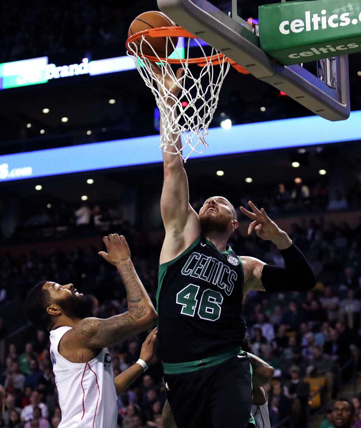 Boston Celtics center Aron Baynes (46) tips in a rebound over Washington Wizards forward Markieff Morris during the first quarter of an NBA basketball game in Boston, Wednesday, March 14, 2018. (AP Photo/Charles Krupa)