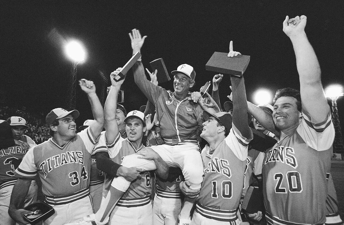 FILE - In this June 10, 1984, file photo, Cal State Fullerton Coach Augie Garrido, center, is lifted by his 1984 NCAA Baseball Championship Team as they celebrate after a 3-1 victory over Texas in the College World Series final baseball game in Omaha, Neb. Garrido, who won three national baseball championships at Cal State Fullerton and two more at Texas, has died, the University of Texas announced Thursday, March 15, 2018. He was 79. (AP Photo/File)