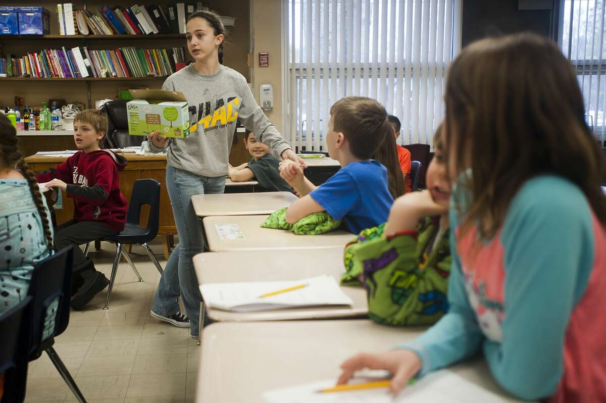 Bullock Creek High School freshman Rita Gorsuch passes out snacks to second graders on Thursday, March 15, 2018 at Floyd Elementary. Gorsuch is part of a group called Creekers for a Cause, which chose to visit classrooms in honor of "Incredible Kid Day" on Thursday. (Katy Kildee/kkildee@mdn.net)