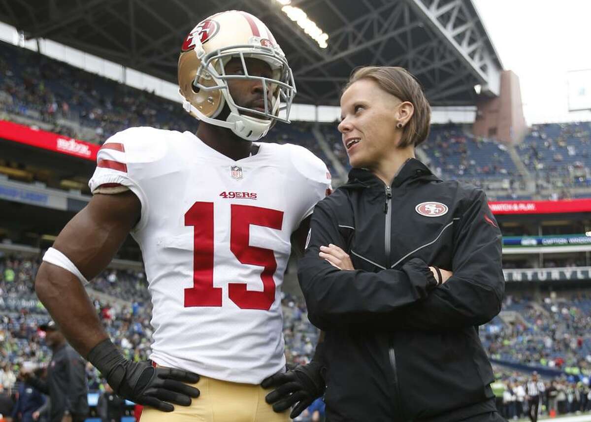 Pierre Garcon #15 and Offensive Assistant Coach Katie Sowers of the San Francisco 49ers talk on the field prior to the game against the Seattle Seahawks at CenturyLink Field on September 17, 2017 in Seattle, Washington. The Seahawks defeated the 49ers 12-9.