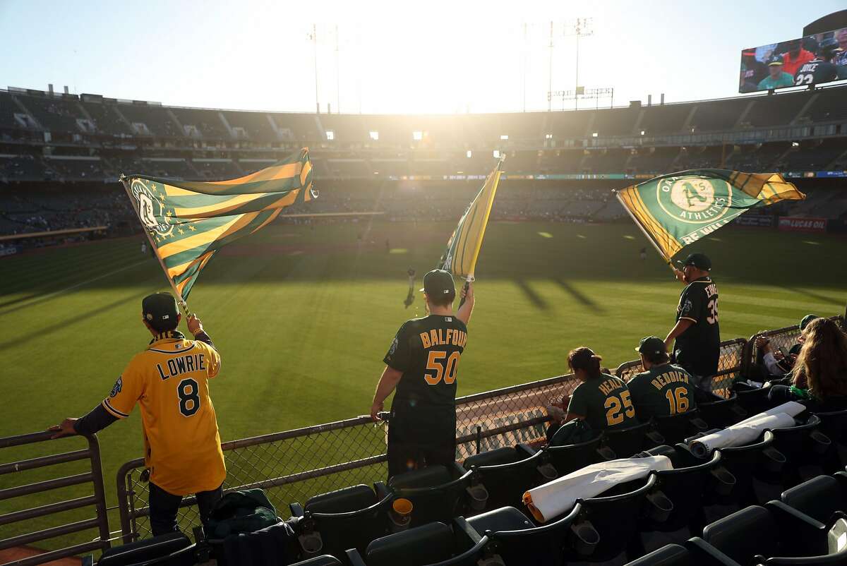 Oakland Athletics' fans in left field bleachers wave flags at Oakland Coliseum in Oakland, Calif. on Monday, July 17, 2017.