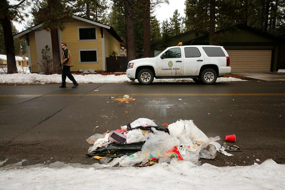 South Lake Tahoe Police, community service officer and vacation house rental specialist, Louis Klingelhoffer walks through the Al Tahoe neighborhood where a pile of trash, which may be the work of a bear, lies in the roadway in South Lake Tahoe, Calif., on Sun. March 11, 2018. One of the ordinances requires all trash to be deposited in a "Bear box" in front of the home. The City of South Lake Tahoe has a strict Vacation Home Rental Ordinance (VHR) with fines of $1,000 for violations.