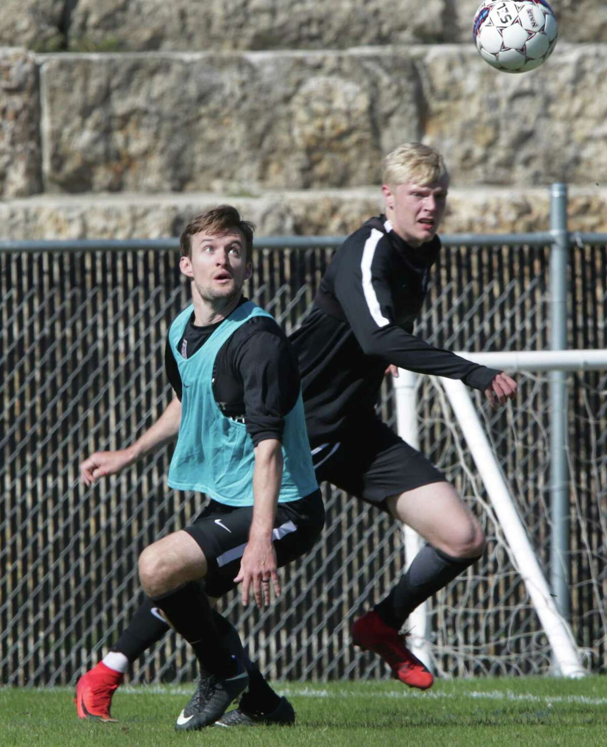San Antonio FC defender Greg Cochrane (left) watches the ball in front of midfielder Connor Presley during training camp.