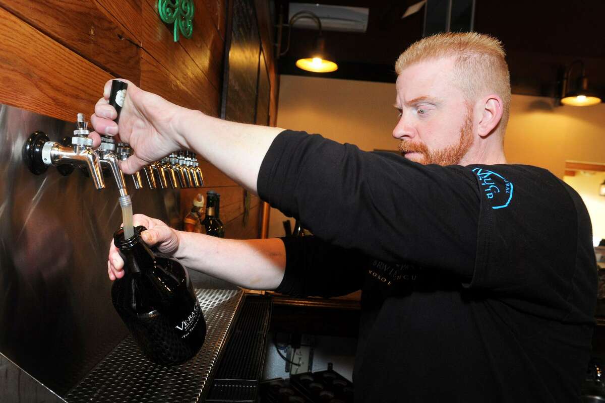 Jeff Janosko, operations manager, fills a growler of beer at Veracious Brewing in Monroe on Thursday.