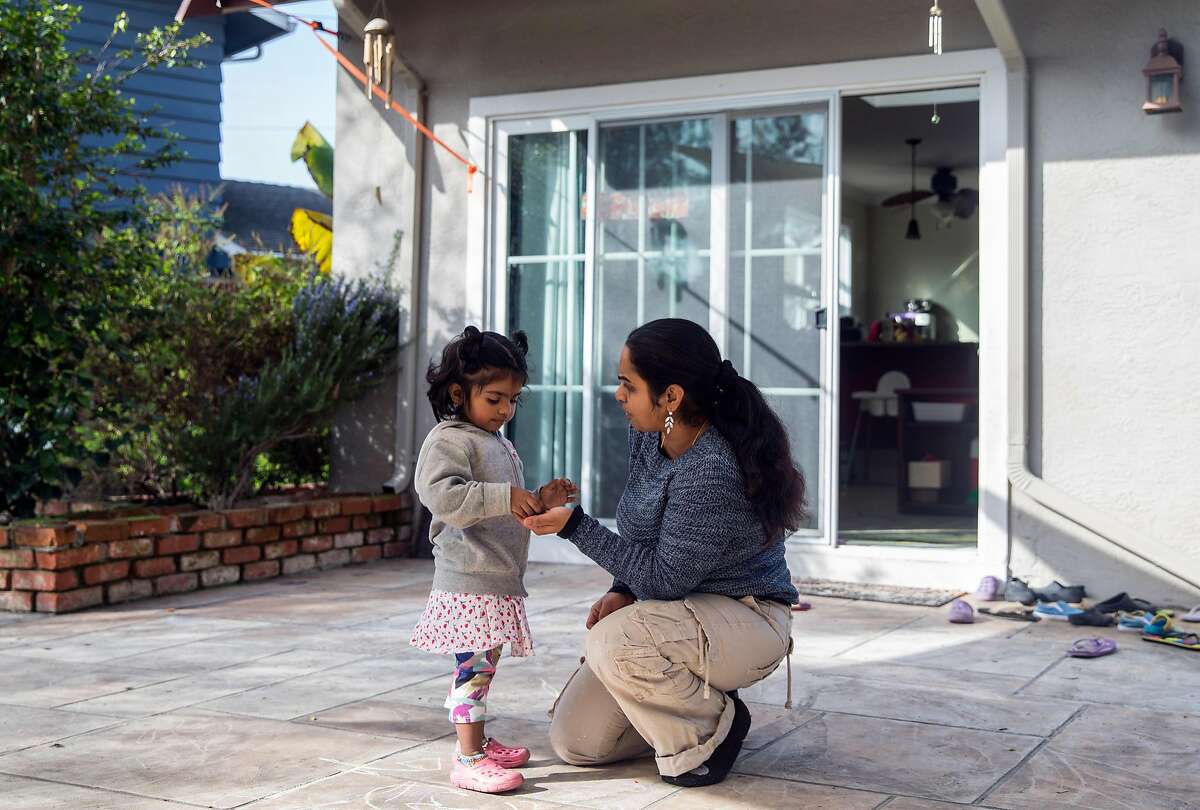 Renuka Sivarajan solves a problem with Sanjana, 3, Wednesday, Jan. 17, 2018 in the backyard of her home and day care center in Fremont, Calif.