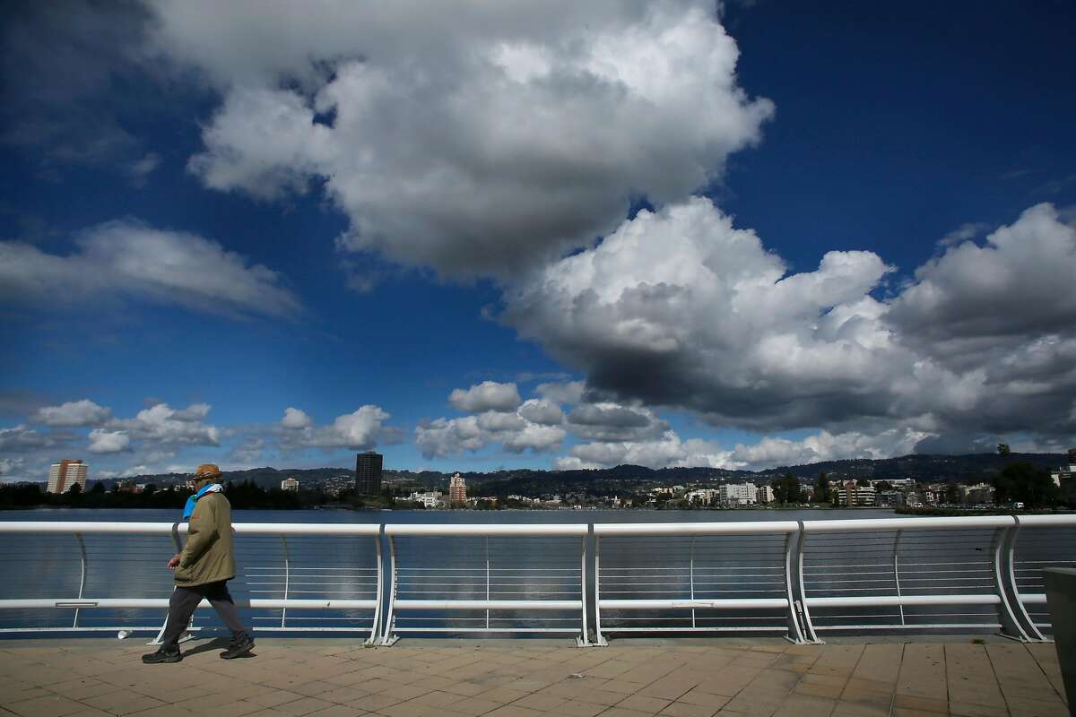 People take advantage of a break in the rain for a stroll around Lake Merritt, as seen Wed. March 14, 2018, in Oakland, Calif.