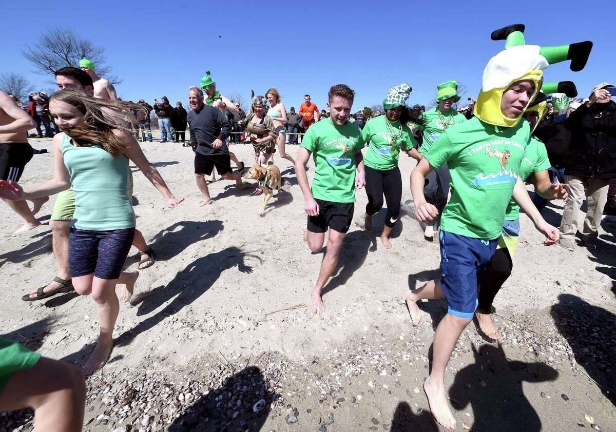 Leapers run into the Long Island Sound for the Leprechaun Leap at Walnut Beach in Milford on March 17, 2018. The event raised money for the Literacy Volunteers of Southern Connecticut.