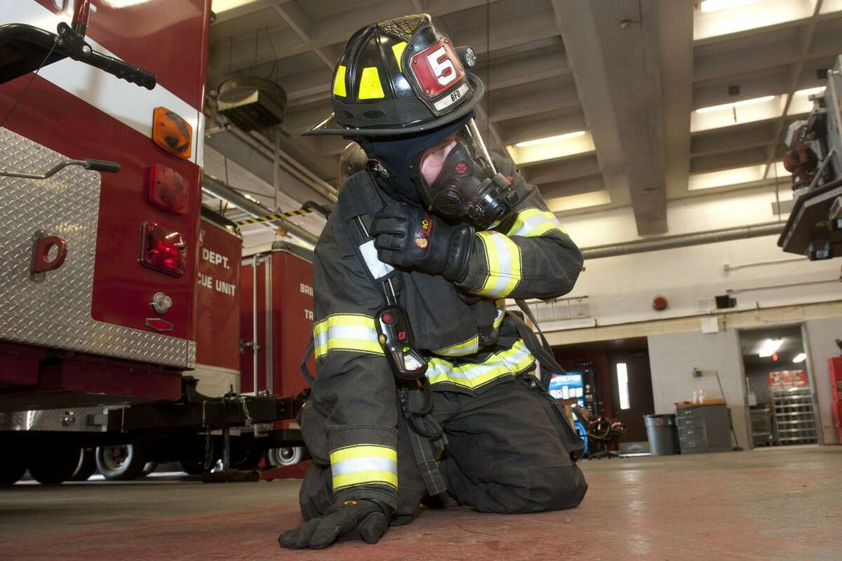 Bridgeport firefighter Justin Fontan takes part in a ?“mayday?” drill at fire headquarters in Bridgeport, Conn. March 9, 2018. During the drill, firefighters dressed in full protective gear learn to communicate their condition and location via a radio in their breathing apparatus in the event they become stranded or incapacitated during an emergency situation.