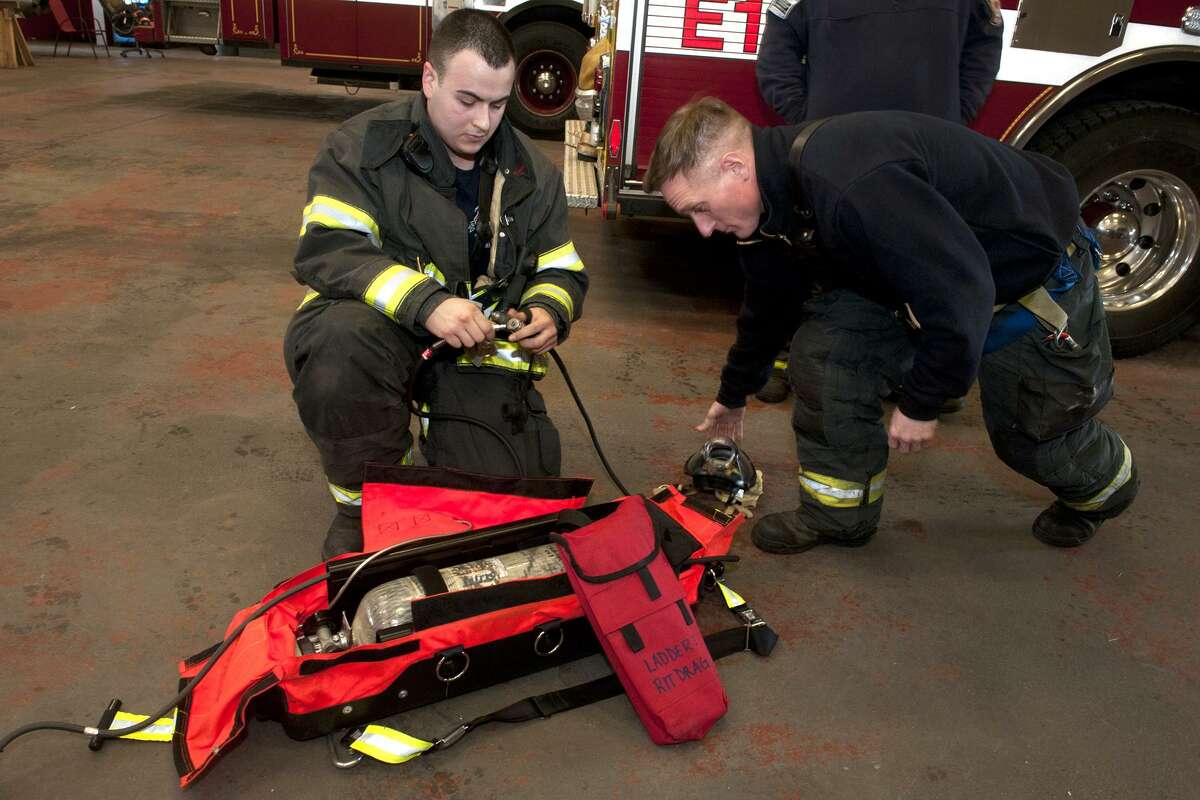Bridgeport firefighters Justin Fontan, left, and Mike Mentes inspect a Rapid Intervention Team (RIT) pack during a ?“mayday?” drill at fire headquarters in Bridgeport, Conn. March 9, 2018. Rapid Intervention Teams stand by at the scene of fire to assist fellow firefighters in the event they become stranded or incapacitated. The RIT packs are stocked with an addition oxygen tank and emergency first aid supplies.
