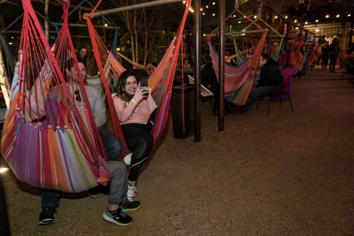 Patrons sit in hammocks in the outdoor garden listening to Kermit Ruffins perform at Axelrad Beer Garden on Wednesday, March 7, 2018, in Houston.
