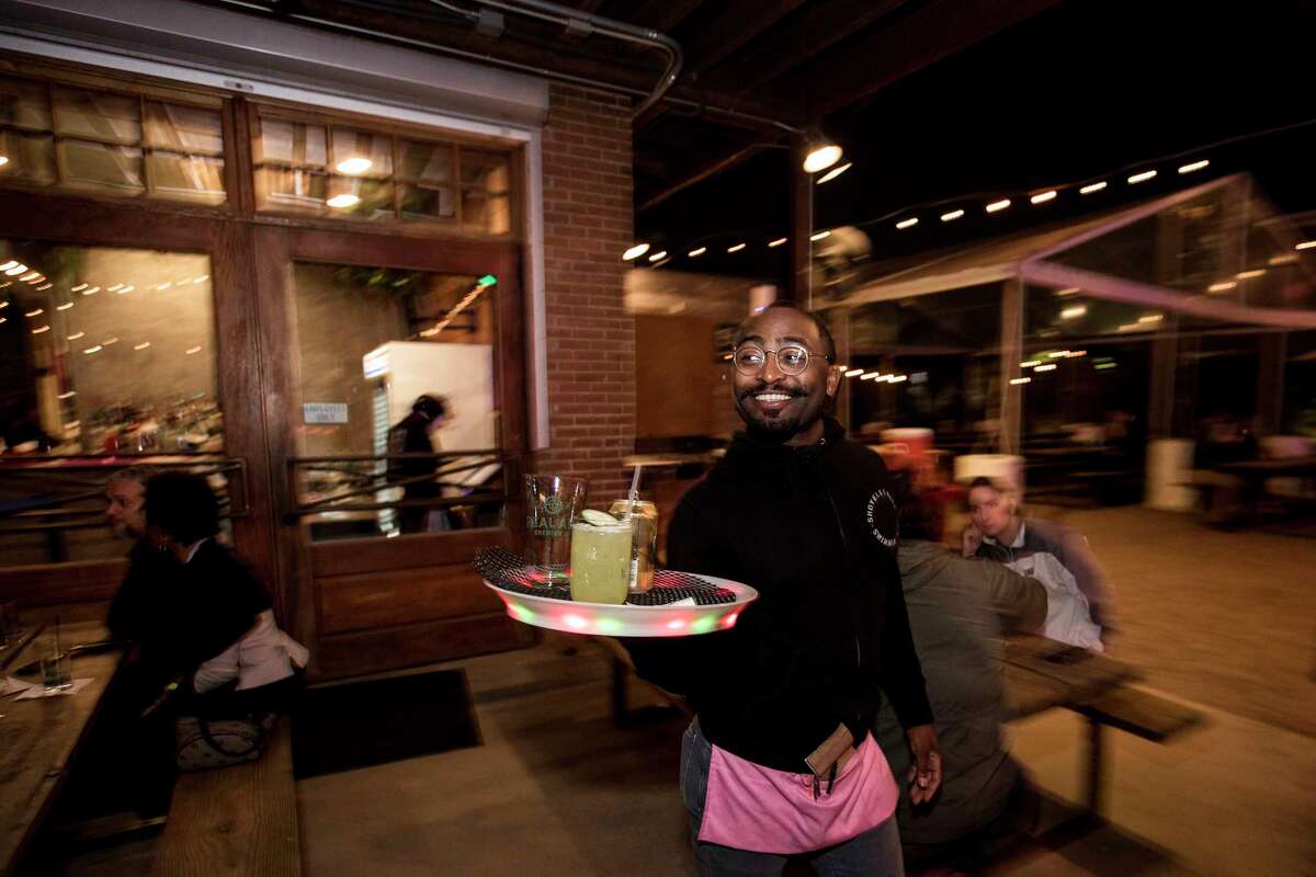 Zachary Taylor carries out a tray of drinks at Axelrad Beer Garden on Wednesday, March 7, 2018, in Houston.