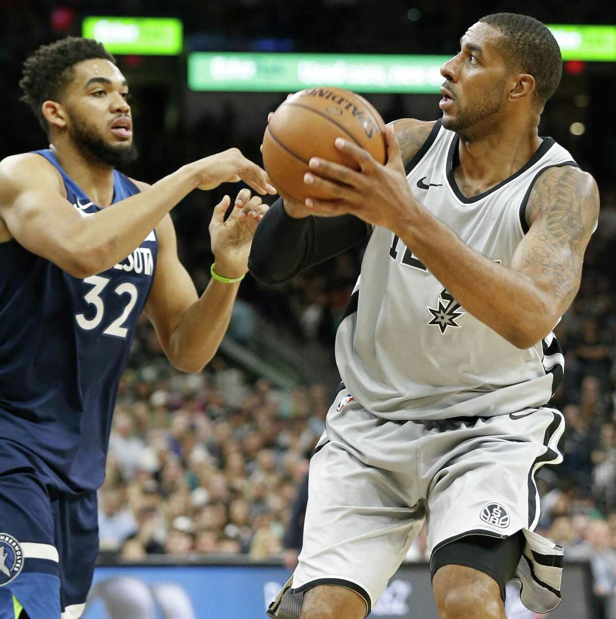 The Spurs’ LaMarcus Aldridge looks for room around Minnesota’s Karl-Anthony Towns during Saturday’s game. Aldridge finished with 39 points and 10 rebounds as the Spurs kept their postseason hopes alive.