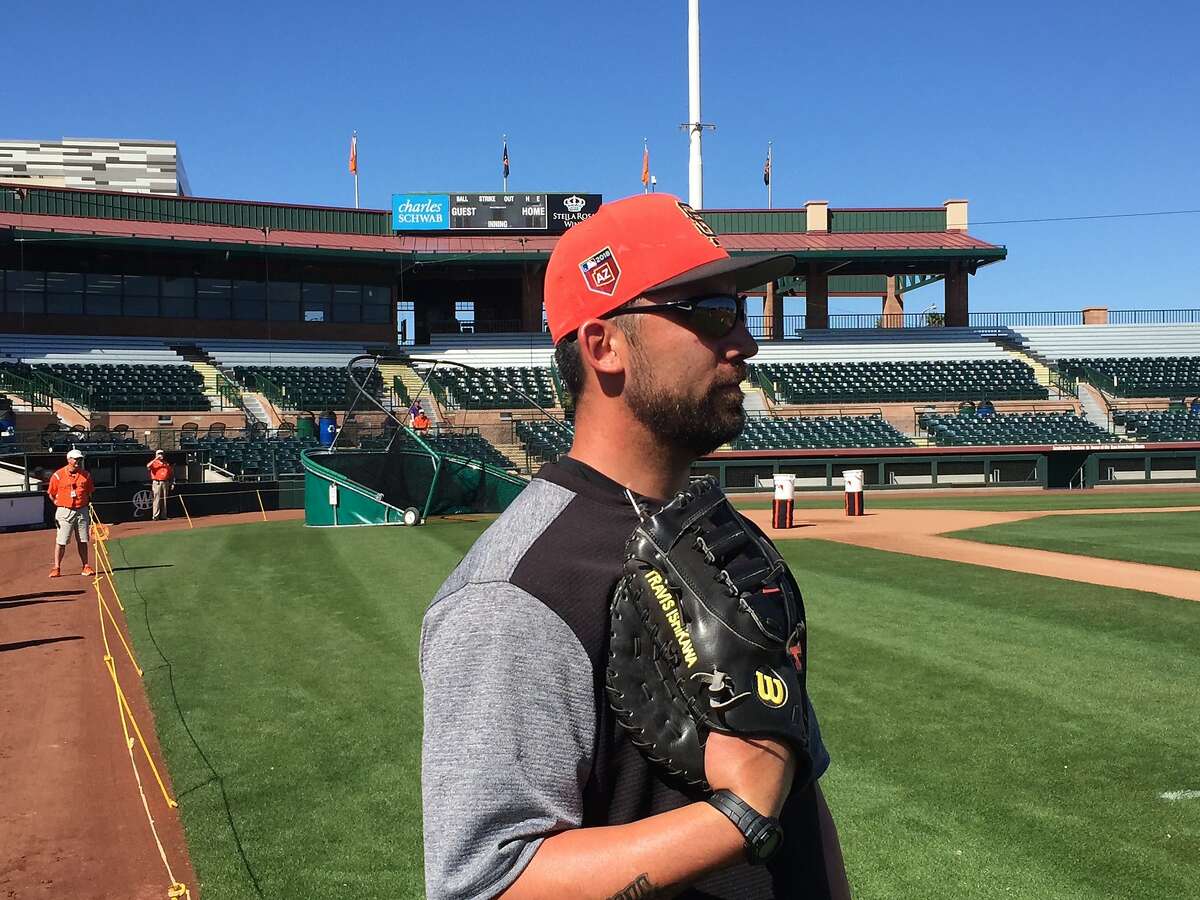 Former Giant Travis Ishikawa looks watches the Giants practice during a workout at Scottsdale Stadium on Monday.