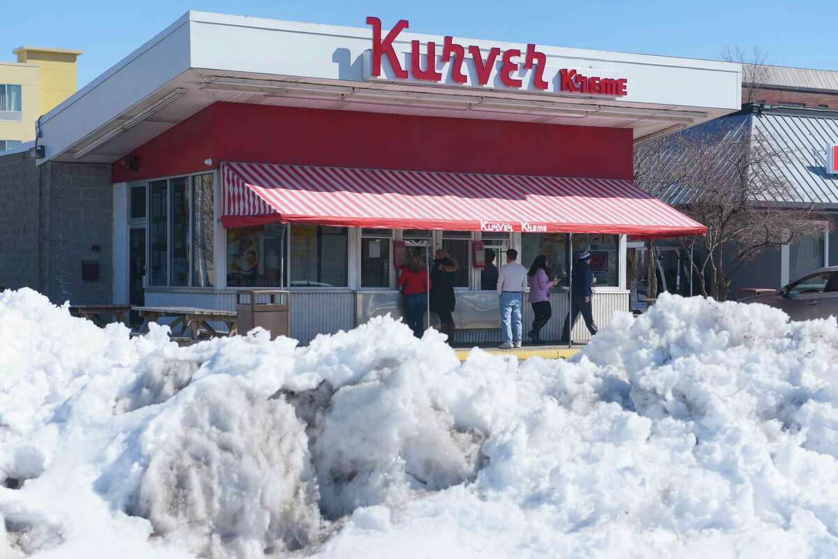 Snow banks line the parking lot as customers get their ice cream during opening day at the Kurver Kreme on Monday, March 19, 2018, in Colonie, N.Y. This is the 66th year of operation for the ice cream stand. The stand will be open Monday through Friday from 11:00am to 9:00pm, Saturday Noon to 9:00pm and Sunday 1:00pm to 9:00pm. Kurver also has for the second year, Dole vegan frozen treat. (Paul Buckowski/Times Union)