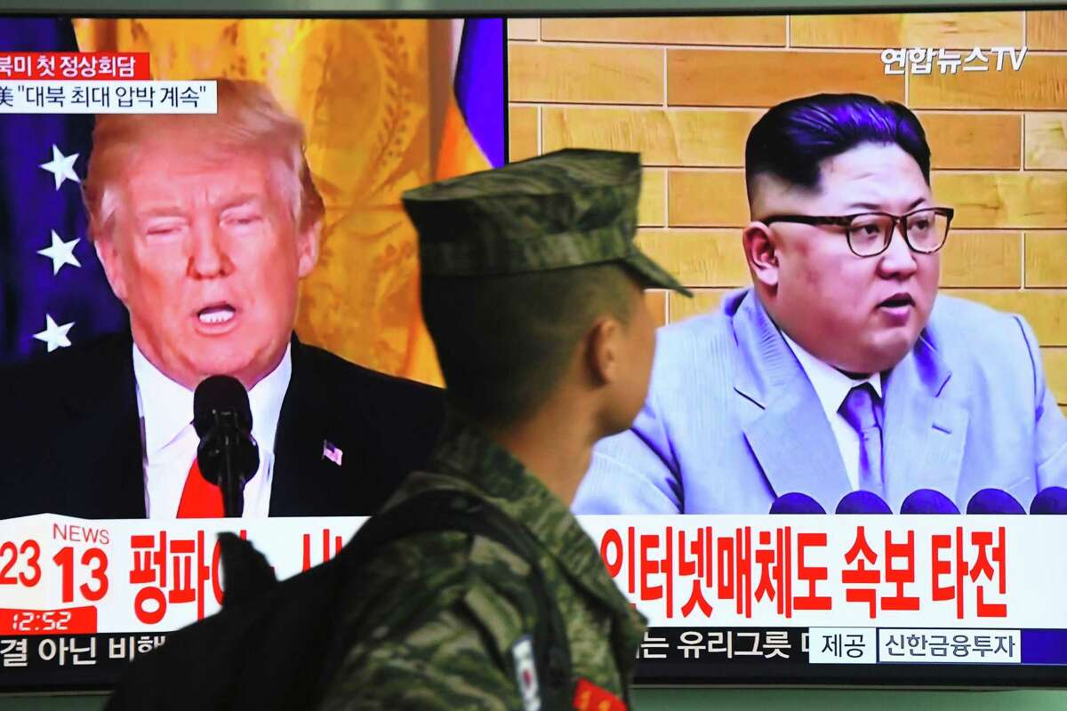 A South Korean soldier walks past a television screen showing pictures of President Donald Trump and North Korean leader Kim Jong Un at a railway station in Seoul on March 9, 2018. Trump agreed on March 8 to a historic first meeting with North Korean leader Kim Jong Un in a stunning development in America's high-stakes nuclear standoff with North Korea.