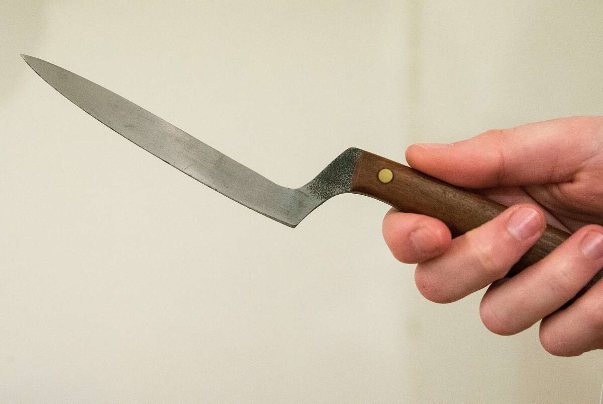A sales associate holds a knife crafted by 19-year-old Everett Noel Saturday, March 17, 2018 at Perish Trust in San Francisco, Calif.
